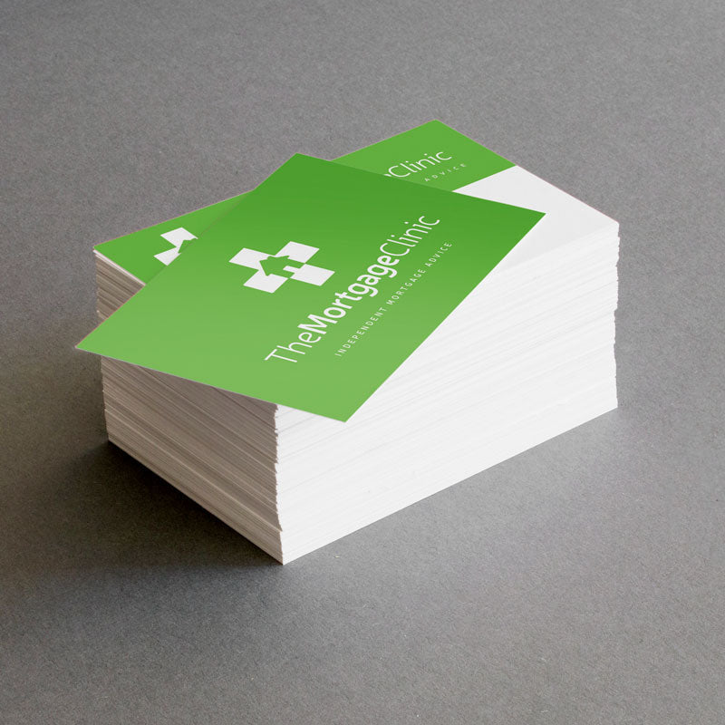 Stack of green and white business cards with 'The Mortgage Clinic' logo on a gray background
